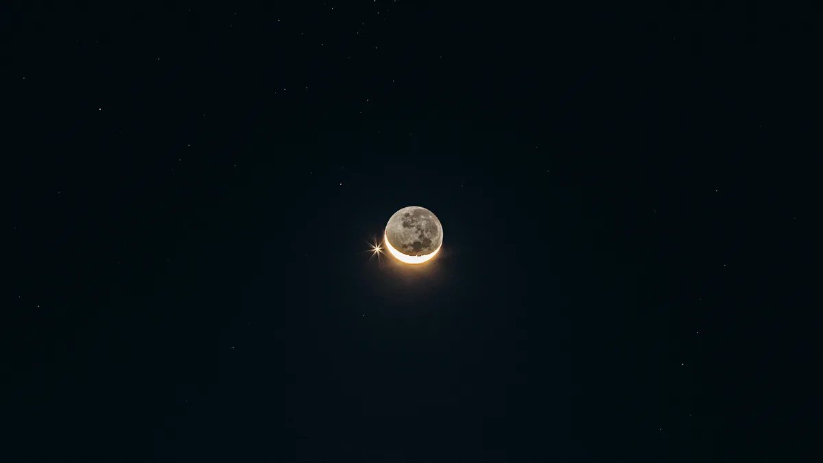 Lua crescente brilhando em céu noturno escuro pontilhado de estrelas
