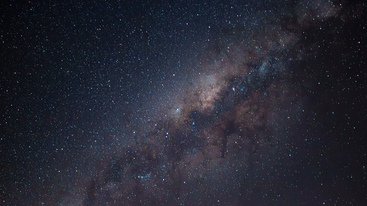 Faixa da Via Láctea cortando o céu noturno repleto de estrelas