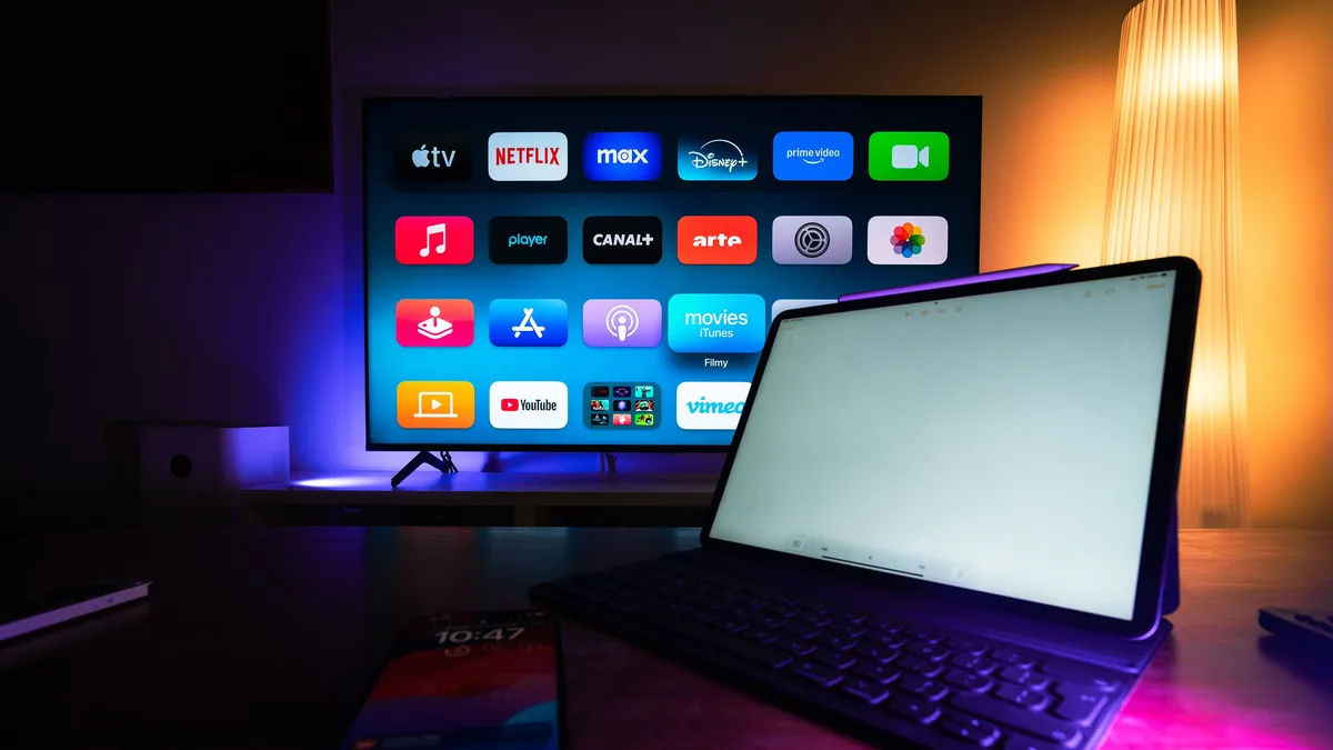 Smart TV e tablet exibem aplicativos de streaming em uma sala moderna