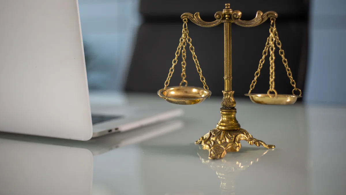 Balança dourada de dois pratos sobre uma mesa, símbolo do signo de Libra